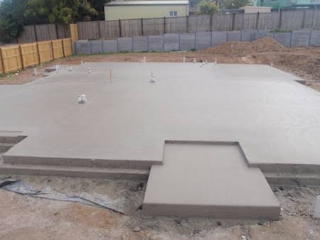 House slab freshly poured and finished, with step-downs at the entry
